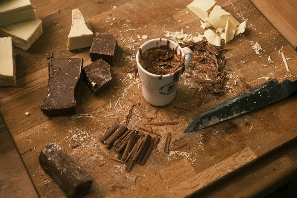 Chocolate bars and shavings artfully arranged with a mug, perfect for culinary themes.